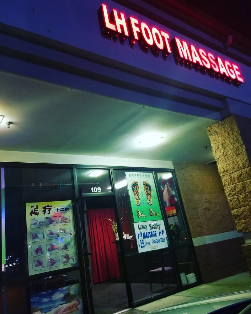 The lit sign outside LH Foot Massage at night, unit 109