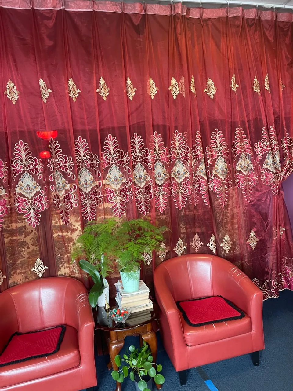 The waiting area, with red armchairs and plants